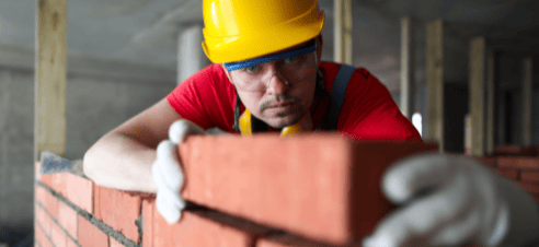 Pedreiro construindo parede de tijolos